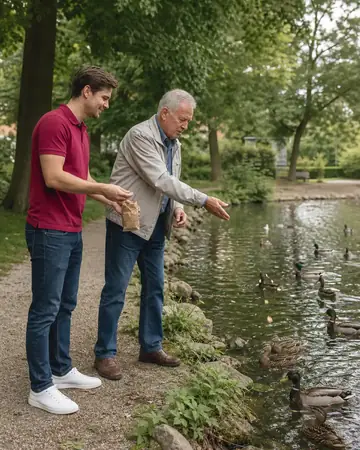 Symbolbild: Betreuer und Senior füttern Enten am Teich
